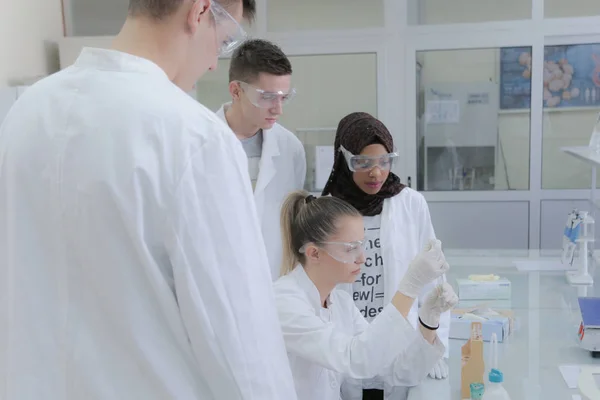 Grupo de jovens cientistas fazendo experimentos em laboratório — Fotografia de Stock