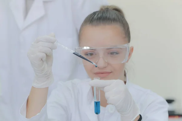 Νεαρή γυναίκα επιστήμονας που κάνει πειράματα στο εργαστήριο — Φωτογραφία Αρχείου