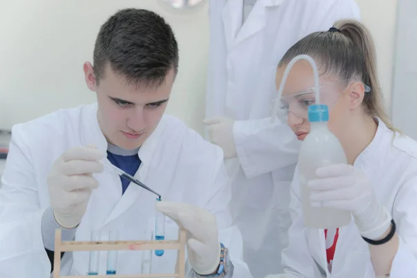 在实验室做实验的年轻科学家小组 — 图库照片