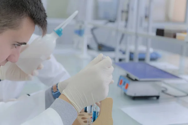 Jonge mannelijke wetenschapper doet experimenten in het laboratorium — Stockfoto