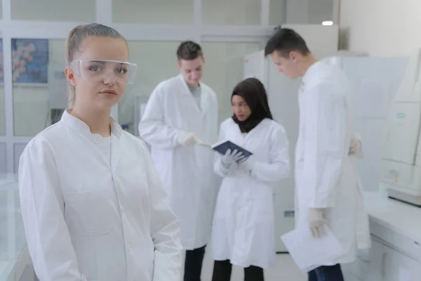 Grupp unga forskare som gör experiment i laboratorium med — Stockfoto