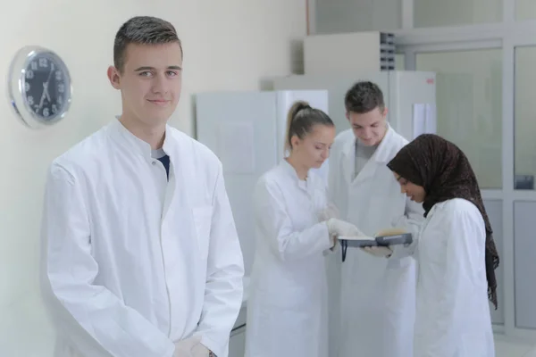 Группа молодых ученых проводит эксперименты в лаборатории с — стоковое фото