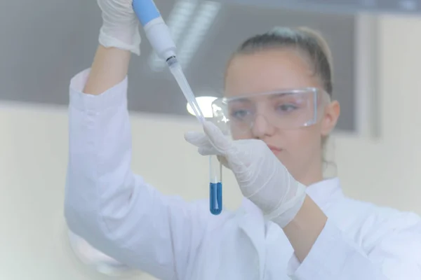 Jonge vrouwelijke laboratoriumwetenschapper werkt in het lab met reageerbuizen — Stockfoto