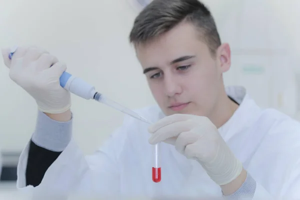 Νεαρός φοιτητής επιστήμονας που εργάζεται στο εργαστήριο με δοκιμαστικούς σωλήνες, — Φωτογραφία Αρχείου