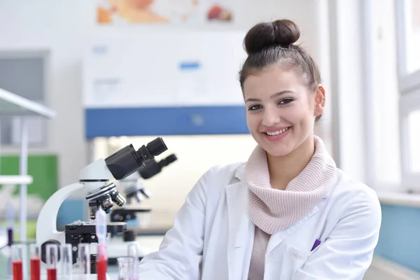 Jonge vrouwelijke wetenschapper kijkt naar camera en glimlacht tijdens exp — Stockfoto
