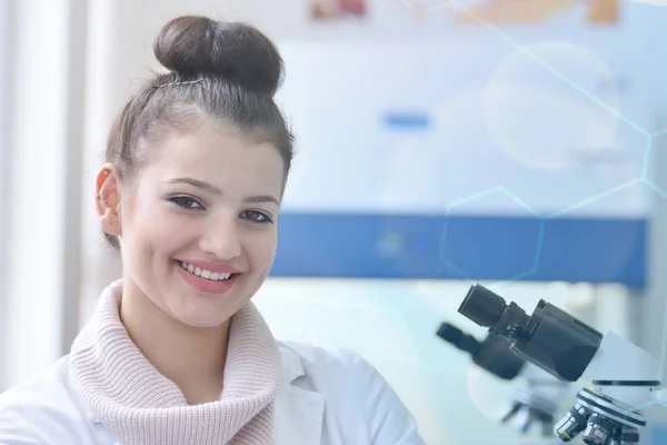 Jonge vrouwelijke wetenschapper kijkt naar camera en glimlacht tijdens exp — Stockfoto