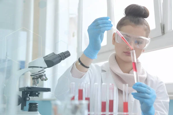 Молодая женщина-лаборант, работающая в лаборатории с пробирками — стоковое фото