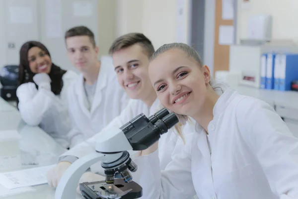 Gruppo di giovani scienziati multietnici che guardano la macchina fotografica e annusano — Foto Stock