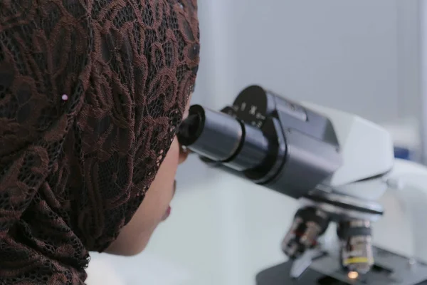 Młoda afrykańska naukowiec patrząc przez mikroskop w — Zdjęcie stockowe