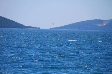 Kıyı manzaralı mavi deniz, yeşil ağaçlar ve orman..