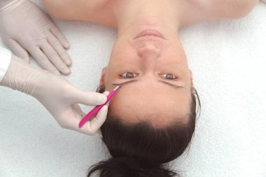 Profesyonel kaş düzeltme ameliyatı olan genç bir kadın. 