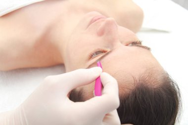 Profesyonel kaş düzeltme ameliyatı olan genç bir kadın. 