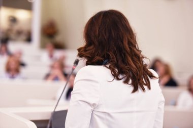 Toplantısında konuşan bir iş kadını. İzleyici olarak conferenc