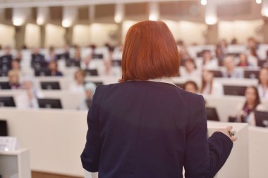Toplantısında konuşan bir iş kadını. İzleyici olarak conferenc