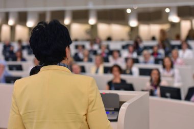 Toplantısında konuşan bir iş kadını. İzleyici olarak conferenc