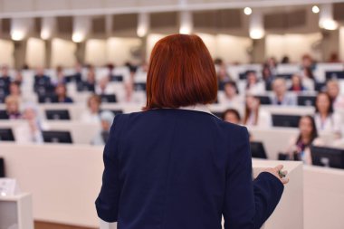 Konferansta lider olarak konuşan bir iş kadını. Seyirciler...