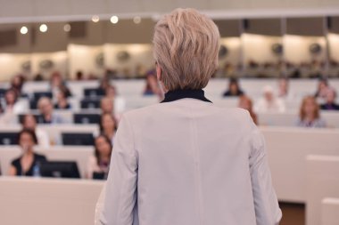 Konferansta lider olarak konuşan bir iş kadını. Seyirciler...