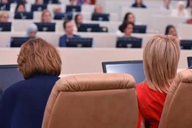 Konferansta lider olarak konuşan bir iş kadını. Seyirciler...