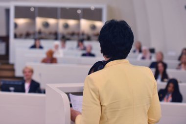 Konferansta lider olarak konuşan bir iş kadını. Seyirciler...