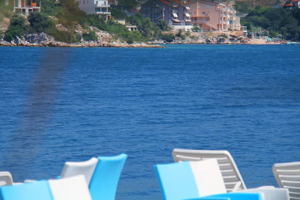 Blått hav med utsikt över stranden med gröna träd och skog. — Stockfoto