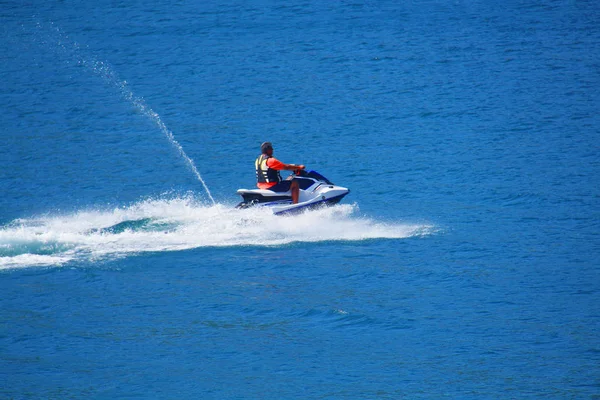 Jeune homme courant la vague sur un jet ski pendant les vacances d'été — Photo