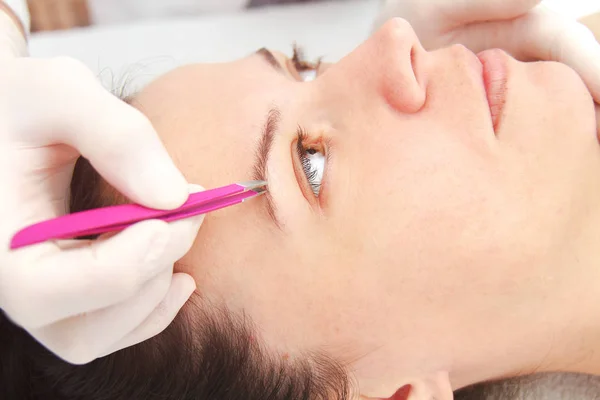 Mujer joven que tiene procedimiento profesional de corrección de cejas en — Foto de Stock