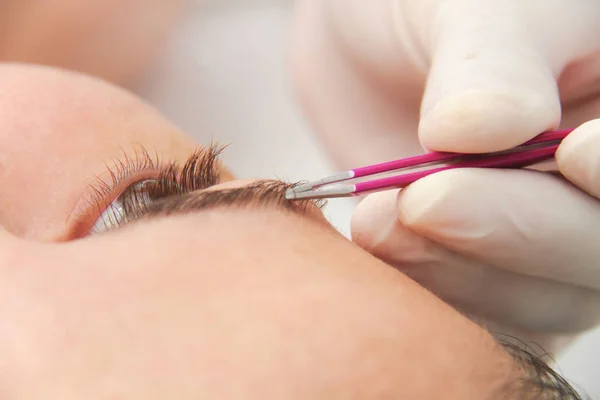 Jonge vrouw met professionele wenkbrauw correctie procedure in — Stockfoto