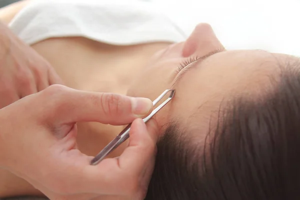 Mujer joven que tiene procedimiento profesional de corrección de cejas en — Foto de Stock