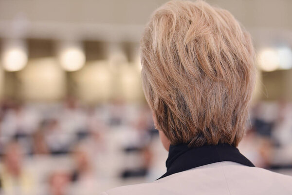 Business woman as leader speaking at Conference. Audience at the