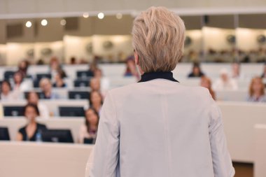 Toplantısında konuşan bir iş kadını. İzleyici olarak conferenc