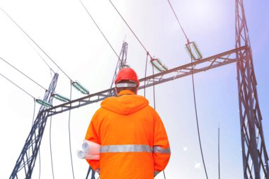 Elektrik mühendisi alt istasyona, arka görüntüye bakıyor.