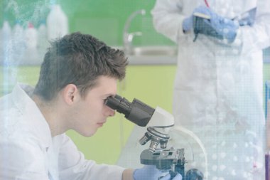 Laboratuvarda test tu ile çalışan iki genç erkek bilim adamı.