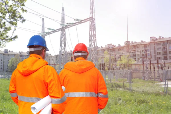 Dos ingenieros eléctricos en subestación, vista trasera — Foto de Stock