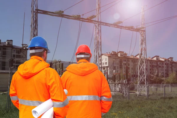 Deux ingénieurs électriciens en sous-station, vue arrière — Photo