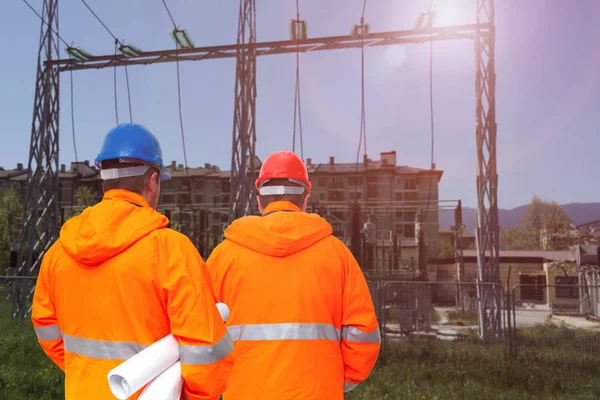 Due ingegneri elettrici in sottostazione, vista posteriore — Foto Stock