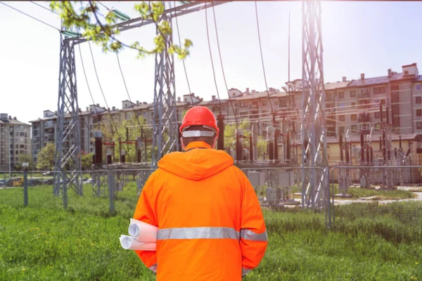 Ingegnere elettrico guardando sottostazione, vista posteriore — Foto Stock