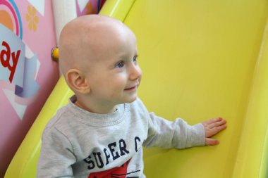 Güzel erkek bebek oyun alanında oynuyor.