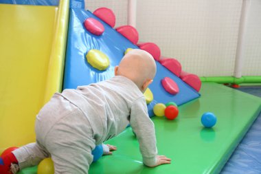 Güzel erkek bebek oyun alanında oynuyor.