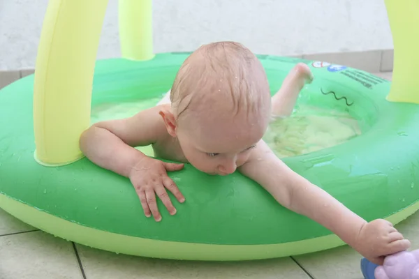 Schöner einjähriger Junge spielt im Schwimmbad — Stockfoto