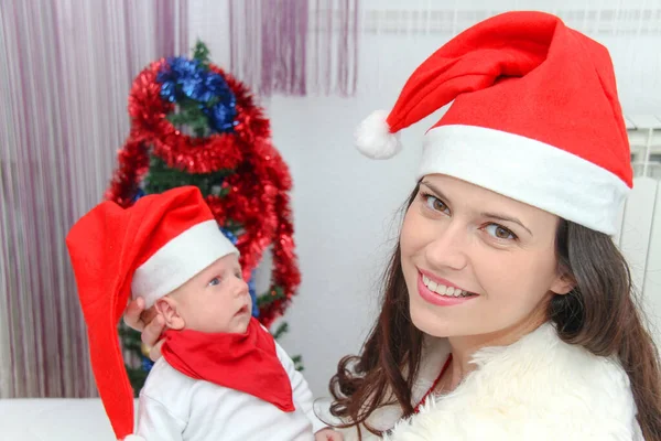 Gelukkig moeder met mannelijke baby dragen kerst hoeden — Stockfoto