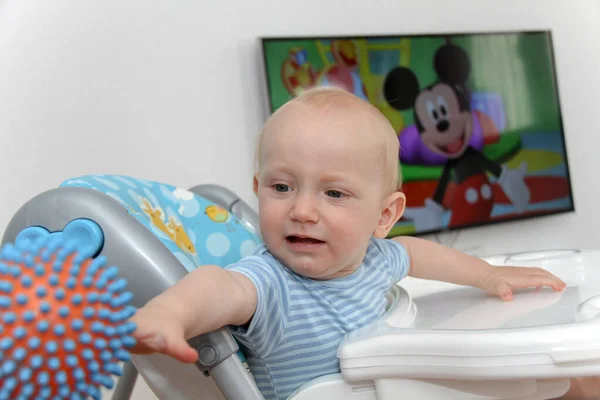 Ein Jahr Baby schaut Zeichentrickfilme im Fernsehen und spielt — Stockfoto