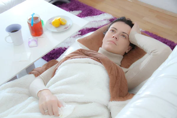 ผู้หญิงป่วยหนุ่มนอนบนเตียง — ภาพถ่ายสต็อก