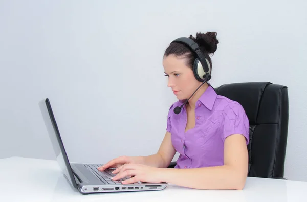 Operador telefónico femenino de atención al cliente con auriculares en el lugar de trabajo —  Fotos de Stock