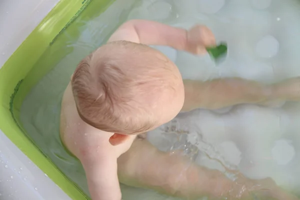 Schöner einjähriger Junge spielt im Schwimmbad — Stockfoto