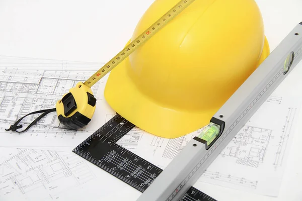 Helmets and tools for construction drawings and buildings — Stock Photo, Image