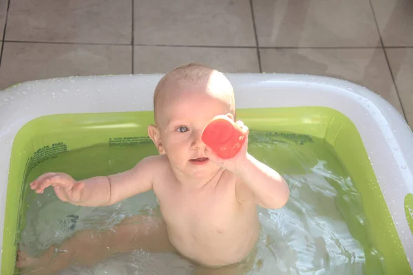 Bonito menino de um ano brincando na piscina — Fotografia de Stock