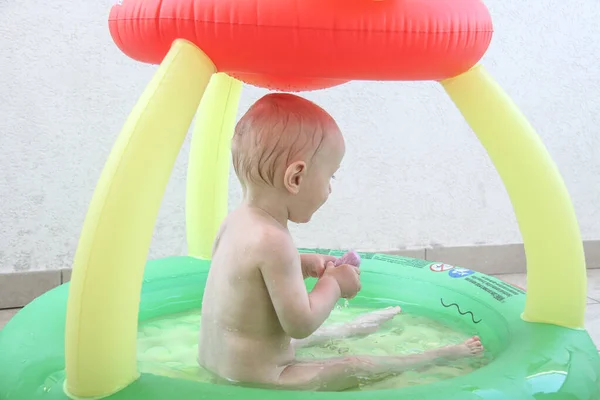 Bonito menino de um ano brincando na piscina — Fotografia de Stock