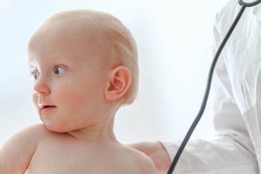 One year old sick baby boy at the young female doctor