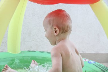 Güzel erkek bebek oyun alanında oynuyor.