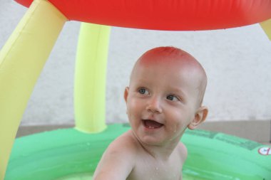 Güzel bir yıl erkek çocuğu yüzme havuzunda oynuyor